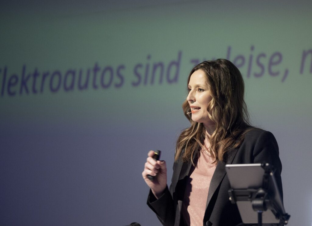 KeynoteSpeakerin Kristina zur Mühlen auf Bühne | mit Presenter in der Hand | Thema Elektroautos