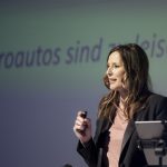 KeynoteSpeakerin Kristina zur Mühlen auf Bühne | mit Presenter in der Hand | Thema Elektroautos
